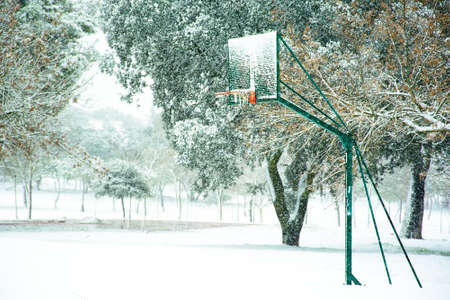 Basketball basket in snowy fieldの写真素材