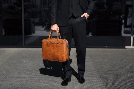 businessman with a brown bag near the office talking on the phone