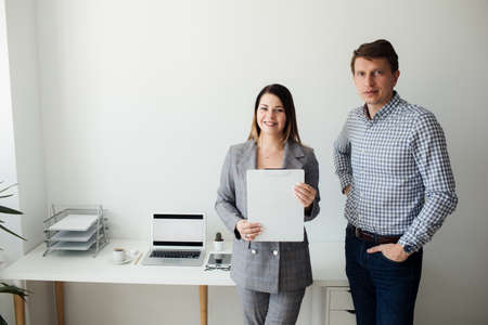 younger girl and man working in the office at the tableの写真素材