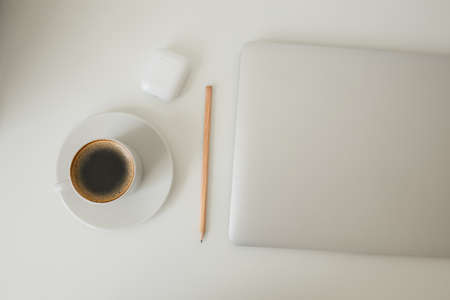 office table on which laptop, coffee, tablet, camera and other itemsの写真素材