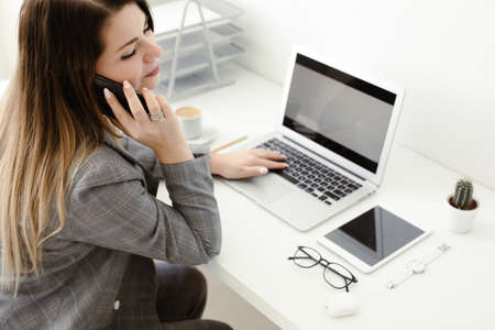 younger girl working in the office at the tableの写真素材