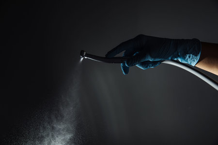 Dentist hand with drill illustrates the operation of the dentist dental drill machine with water....