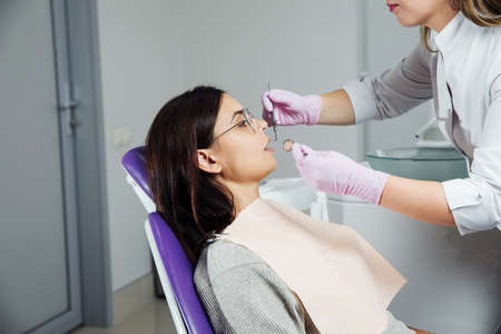 A woman is preparing for a dental examination. Woman having teeth examined at dentists.の写真素材