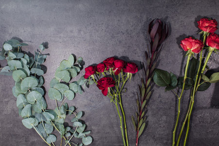 A variety of beautiful flowers lying on a grey table. Flower delivery. The job of a florist