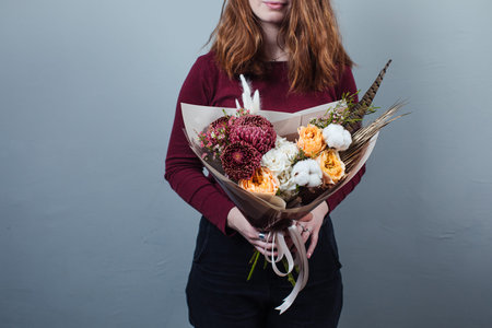 Beautiful bouquet of mixed flowers with peonies. The work of the florist. Flower deliveryの写真素材