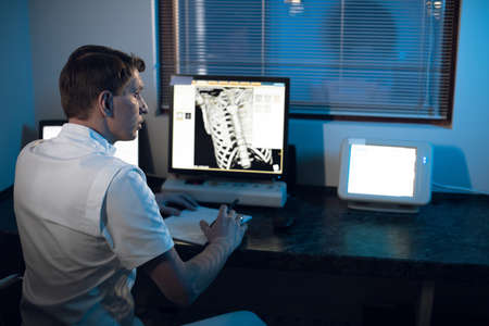 in the Medical Laboratory the Radiologist in the Control room Monitors the Skeleton and ribs of the patient MRI or CTの写真素材