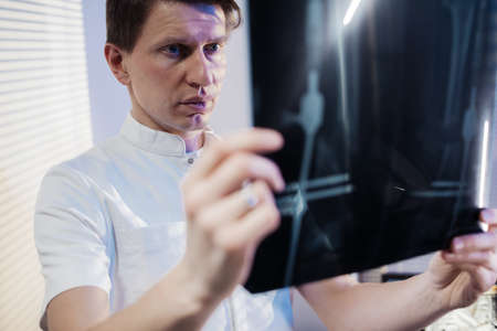 The doctor looks at the patients x-ray. Work of the clinic doctorの写真素材
