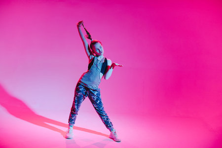 Young stylish girl dancing in the Studio on a colored neon background. Music dj poster design.