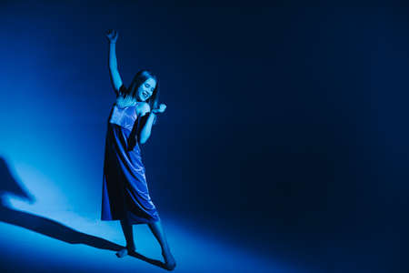 Young stylish girl dancing in the Studio on a colored neon background. Classic dancer.の写真素材