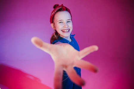 Young stylish girl in the Studio on a colored neon background. Music dj poster design. Portrait of a young girl dancer.の写真素材