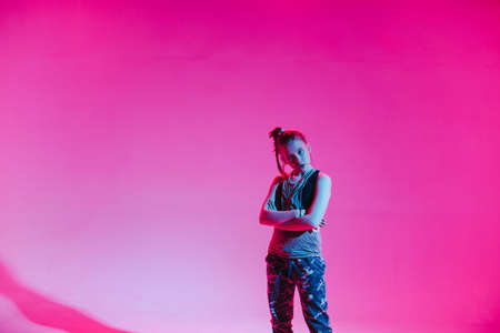 Young stylish girl dancing in the Studio on a colored neon background. Music dj poster design.の写真素材