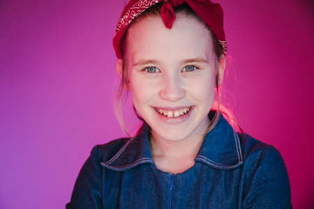 Young stylish girl in the Studio on a colored neon background. Music dj poster design. Portrait of a young girl dancer.の写真素材