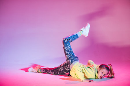 Young stylish girl dancing in the Studio on a colored neon background. Music dj poster design.