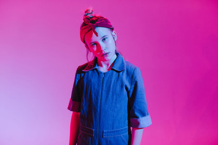 Young stylish girl in the Studio on a colored neon background. Music dj poster design. Portrait of a...