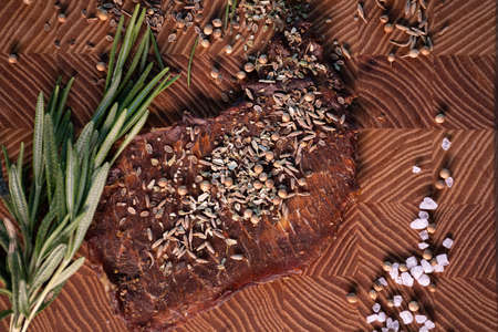 Close-up of a piece of meat on a wooden Board with spices. Restaurant menu, a series of photos of different dishesの写真素材