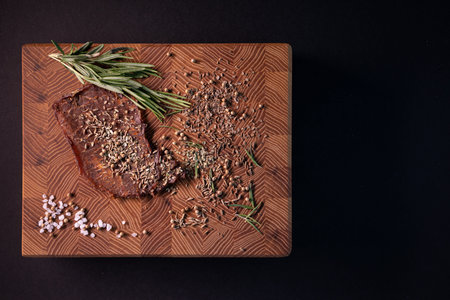 Close-up of a piece of meat on a wooden Board with spices. Restaurant menu, a series of photos of different dishesの写真素材