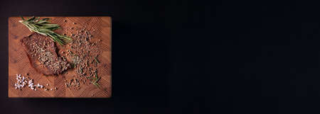 Close-up of a piece of meat on a wooden Board with spices. Restaurant menu, a series of photos of different dishesの写真素材