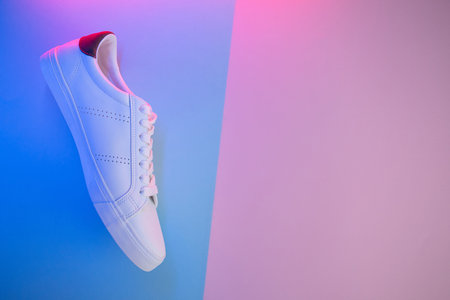 Pair of sneakers on color background, top view