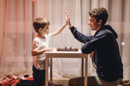 Father and Son play a Board Game in a Cozy Room