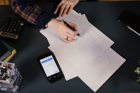 Close - up of the hands of a trader asian girl working at hone at a tableの写真素材