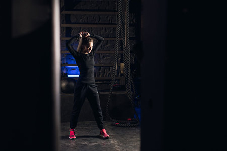 Young girl stands in an atmospheric gym. Sport