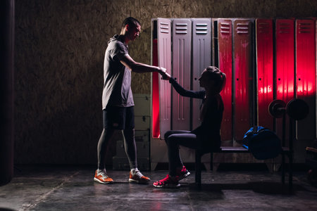 Man and girl get ready for boxing training in the locker roomの写真素材