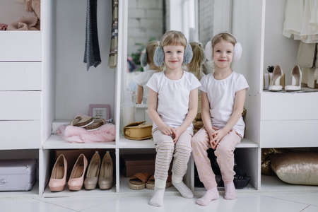 Twin Girls Try On Things in Their Mothers Modern Dressing Room.の写真素材