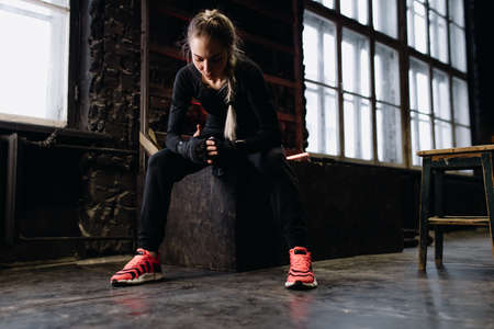 Girl fighter bandages her hands before training in the gym. Red Neon Lightの写真素材
