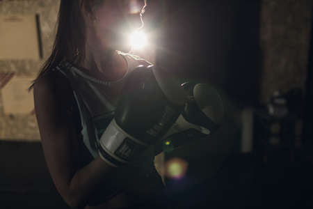 Cool female fighter in boxing bandages trains in gym. Mixed martial artsの写真素材