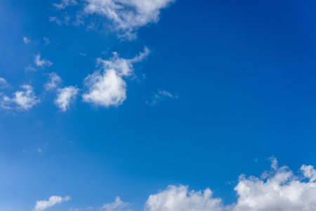 Beautiful fluffy white clouds of varying thickness rolling through a bright, colorful blue daytime...