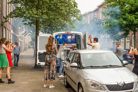 Two men elbow bump outside a social distancing street party van in Hollandのeditorial素材