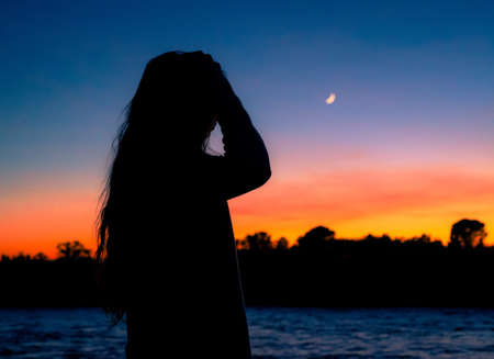 Female silhouette at dusk by the Sacramento River, Northern Californiaの写真素材
