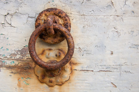 Ancient Italian house: detail of typical painted wood door with rusty iron clapper.の写真素材