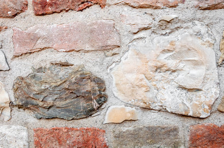 Typical wall of ancient Italian house made of hand-carved stones and bricks