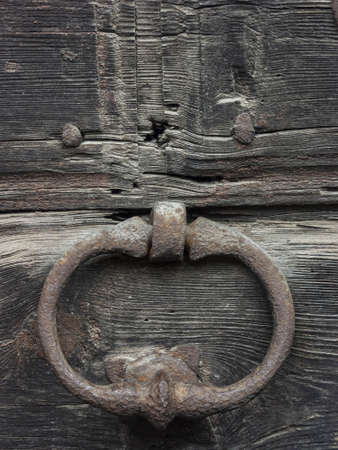 Antique door with wooden plank panels of a rural house, with iron fixing parts, Italy.の写真素材