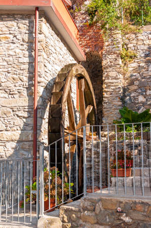 Manarola in the Cinque Terre, Italy. Detail of a house with an old mill wheel in the splendid village, an international tourist destination, immersed in the pristine nature of the marine park.の写真素材