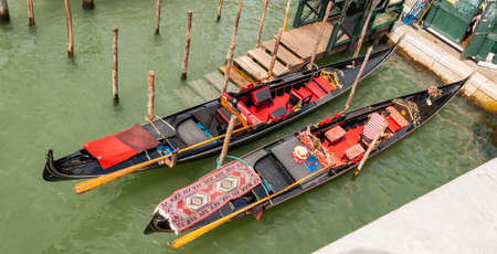 Venice, the city of the lagoon, of the canals, and of carnival masks. Famous throughout the world as one of the most beautiful and romantic cities. Gondola moored in a canal.の写真素材