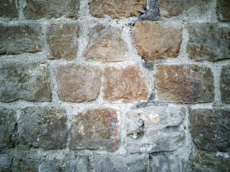 Typical detail of an old wall of an Italian house, made of hand-carved stones eroded by time.の写真素材