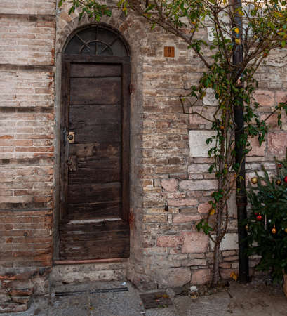 Assisi, the city of peace, Italy.  the birthplace of Saint Francis. Architectural detail with medieval house door in the old town.のeditorial素材