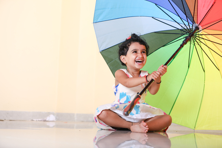 indian girl child with umbrellaの写真素材