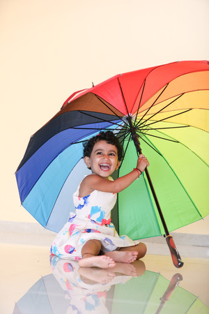 indian girl child with umbrellaの写真素材