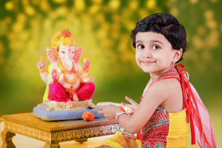 Little Indian girl child with lord ganesha and praying , Indian ganesh festivalの写真素材