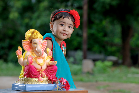 Little Indian girl child with lord ganesha and praying , Indian ganesh festivalの写真素材