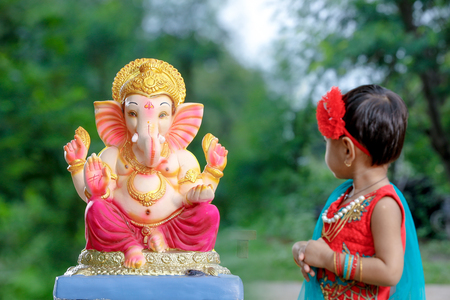 Little Indian girl child with lord ganesha and praying , Indian ganesh festivalの写真素材