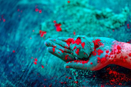 Hand holding a ball of colored powder during Holi festivalの写真素材