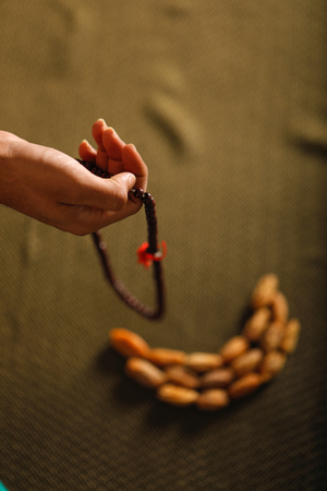 Date fruits with Islamic prayer beads on an artistic background.の写真素材