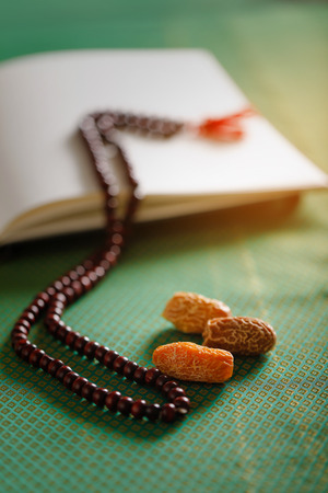 Date fruits with Islamic prayer beads on an artistic background.の写真素材