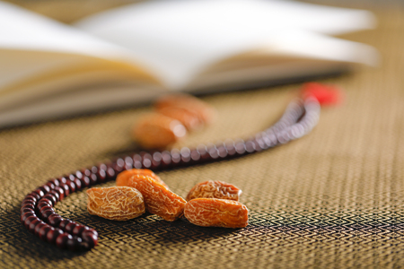 Date fruits with an Islamic prayer beads on an artistic background. Beautiful background for Ramzan or Ramadan.の写真素材