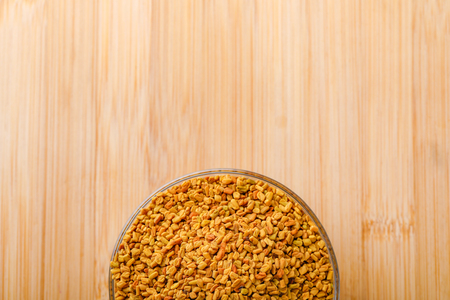 fenugreek seeds in glass bowl on wooden backgroundの写真素材
