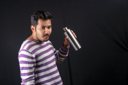 Indian man drinking water with bottleの写真素材